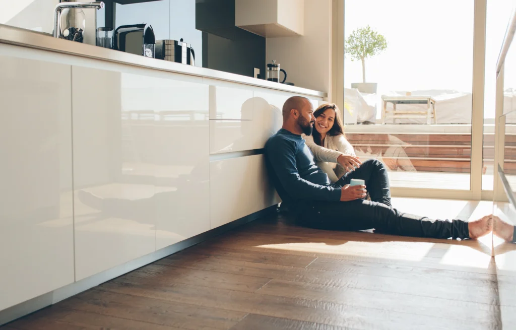 couple lounging on kitchen floor with coffee after roof repairs