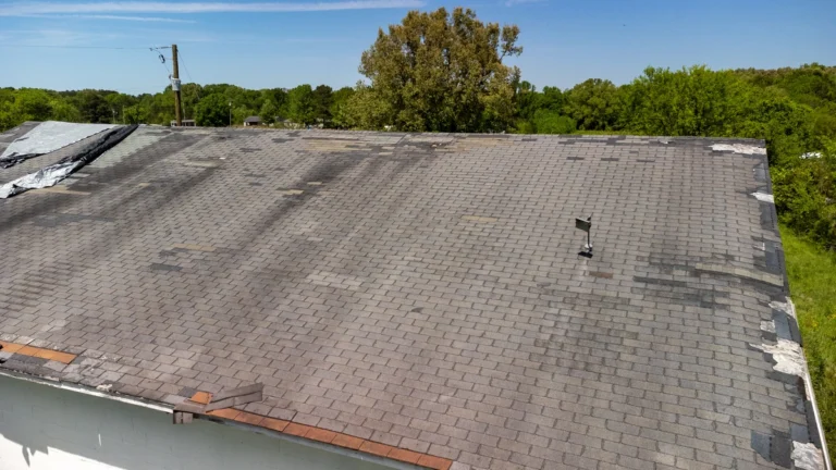 damaged roof after storm with missing shingles and water leak