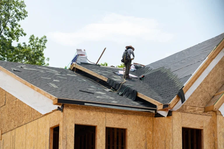 roofers installing asphalt shingle roof on a new house 