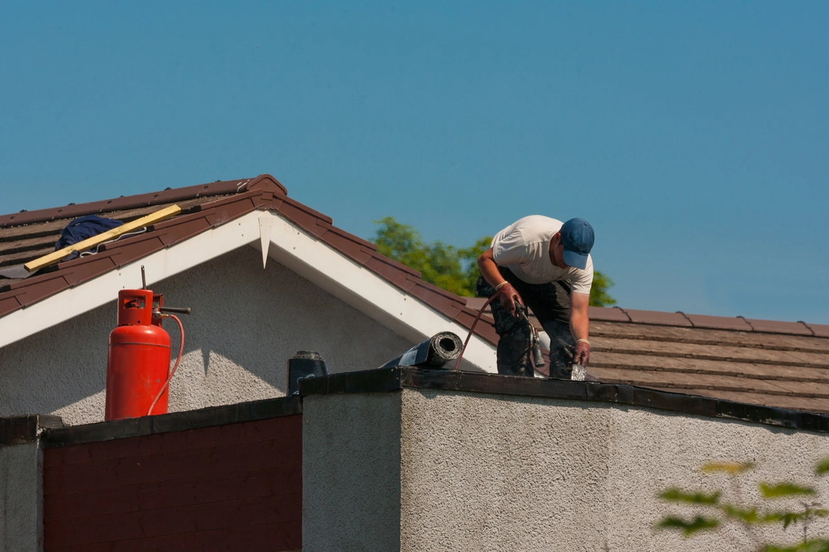 roofer repairing the house roof after a damage