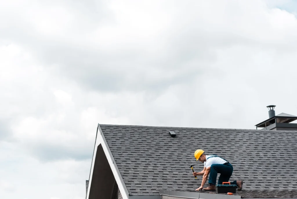 worker wearing helmet repairing the roof