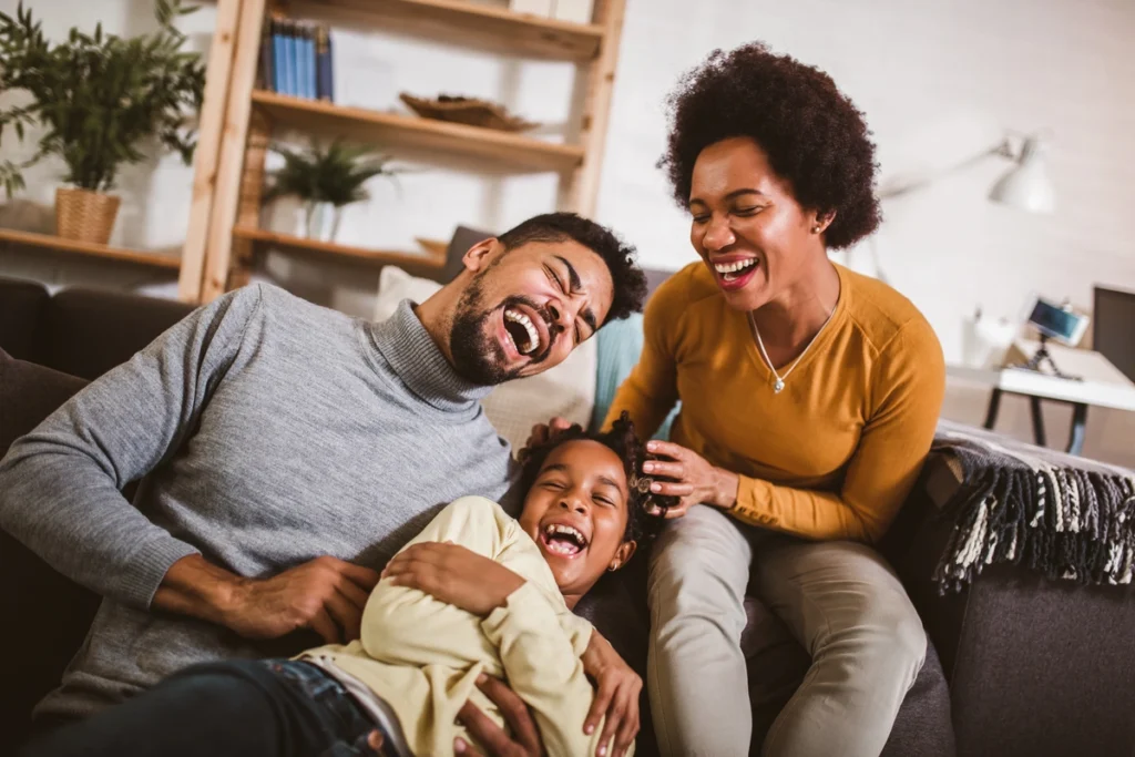 family of three laughing on the couch