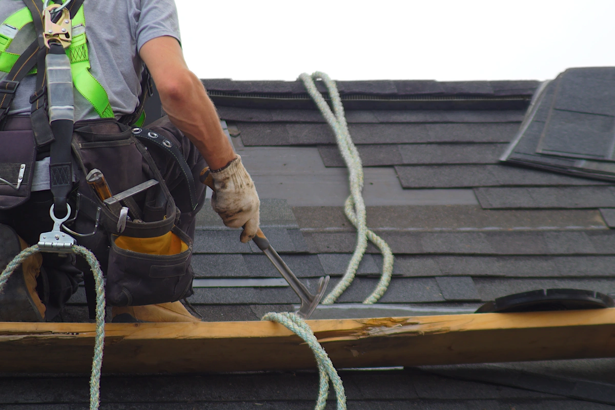 worker removing the old shingles