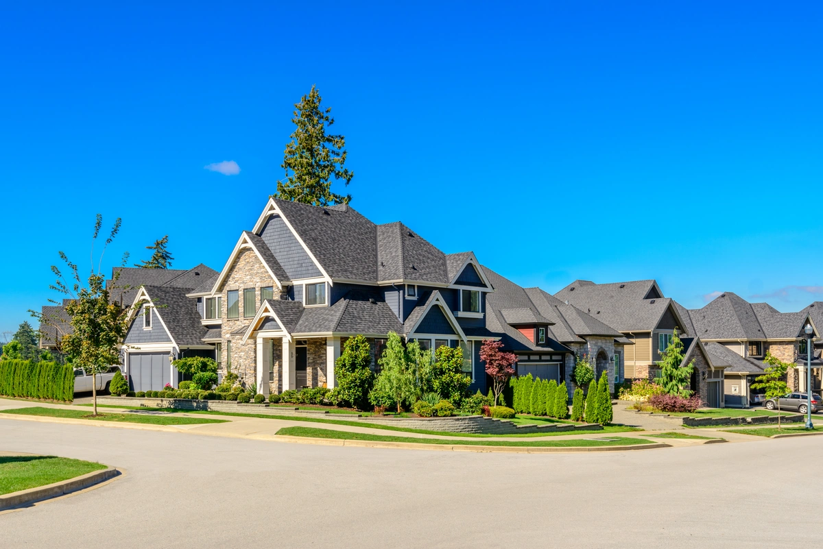 street view of luxury houses with asphalt shingle roofs