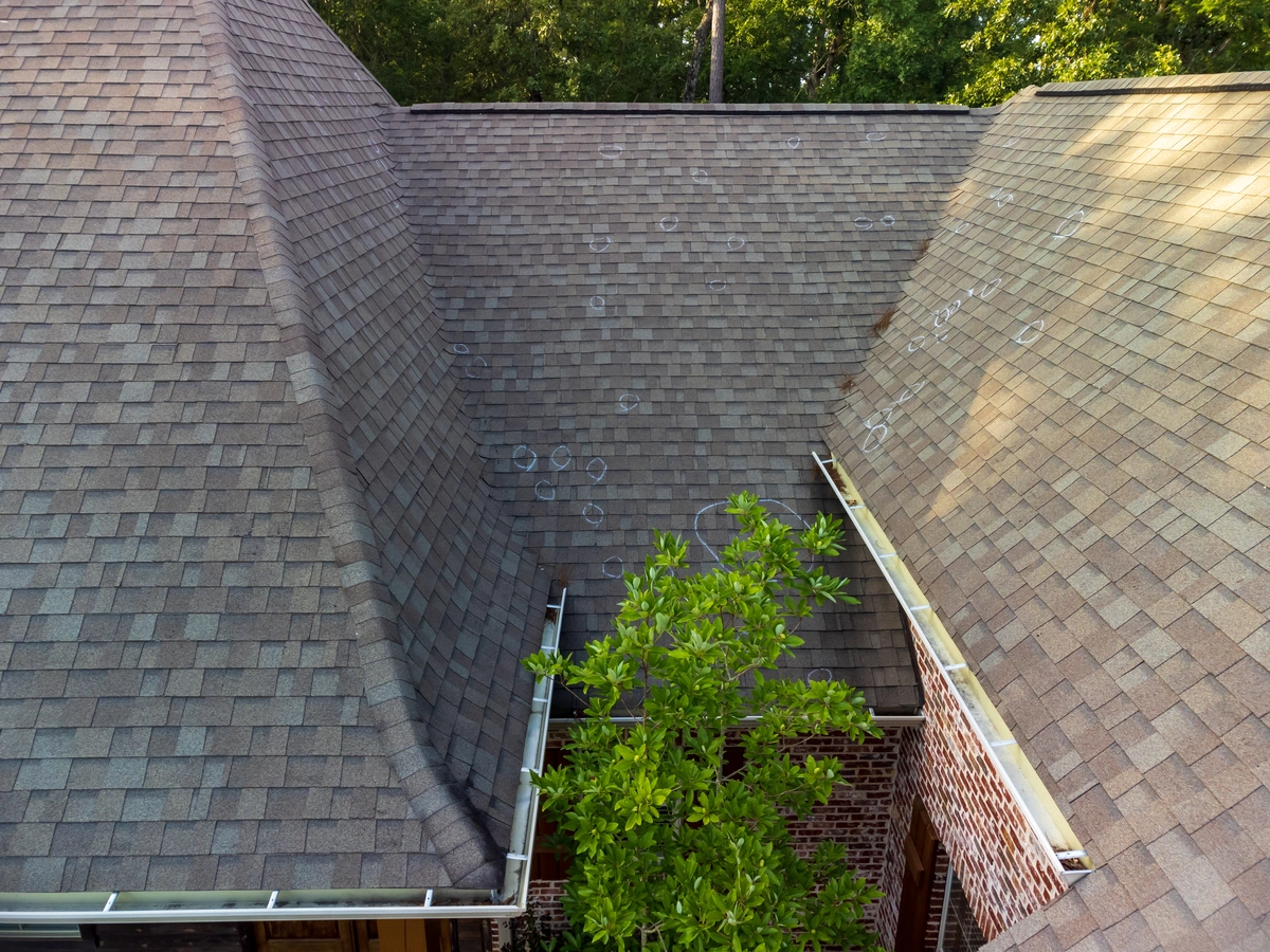 large residential roof with hail damage marks