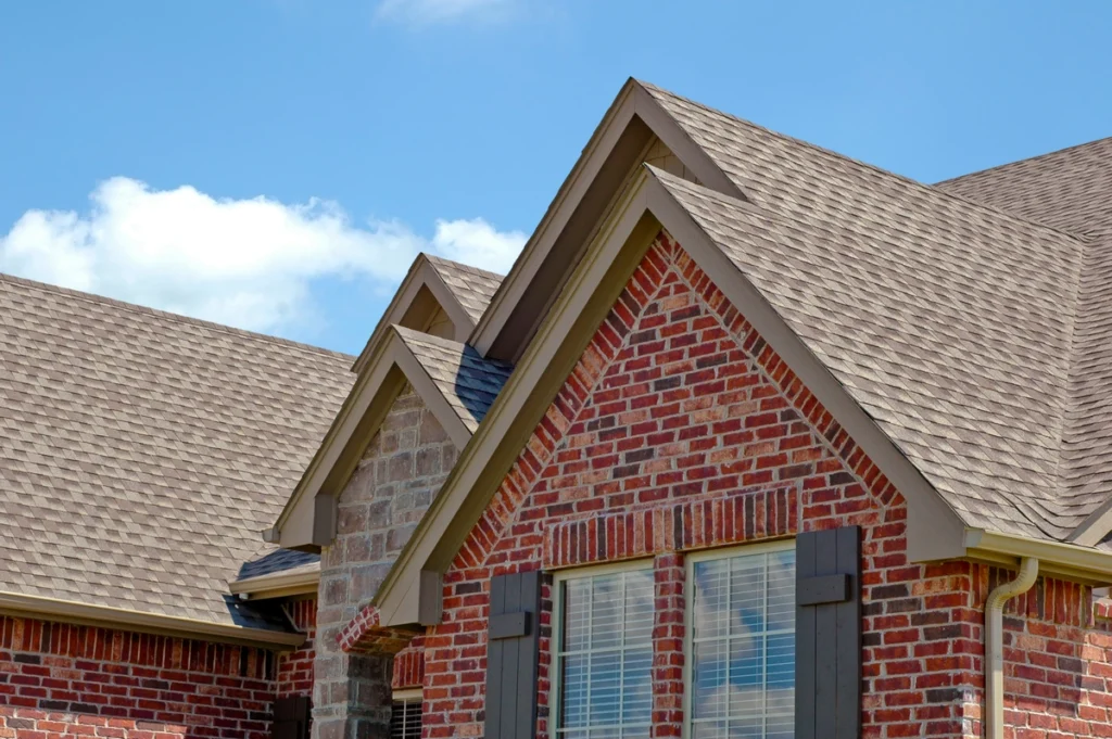 brick house with a gray asphalt shingle roof