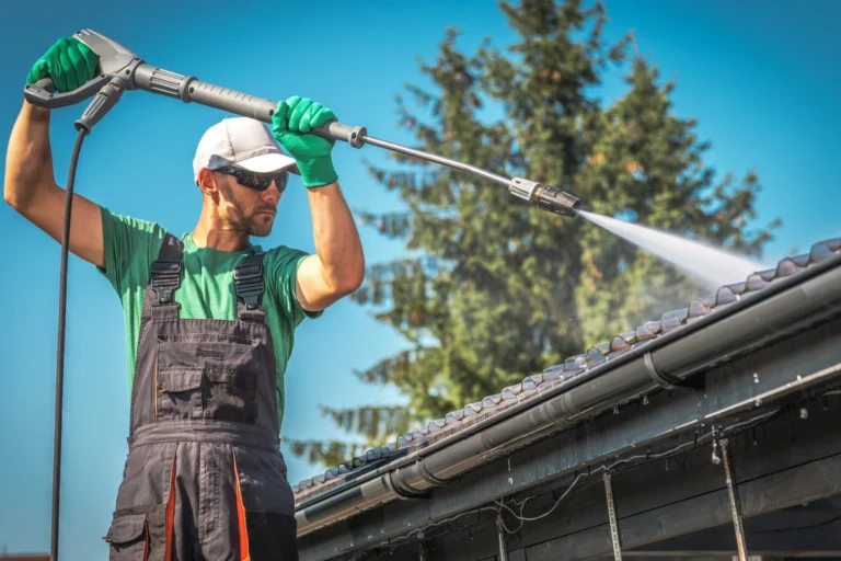 A man powerwashes a roof